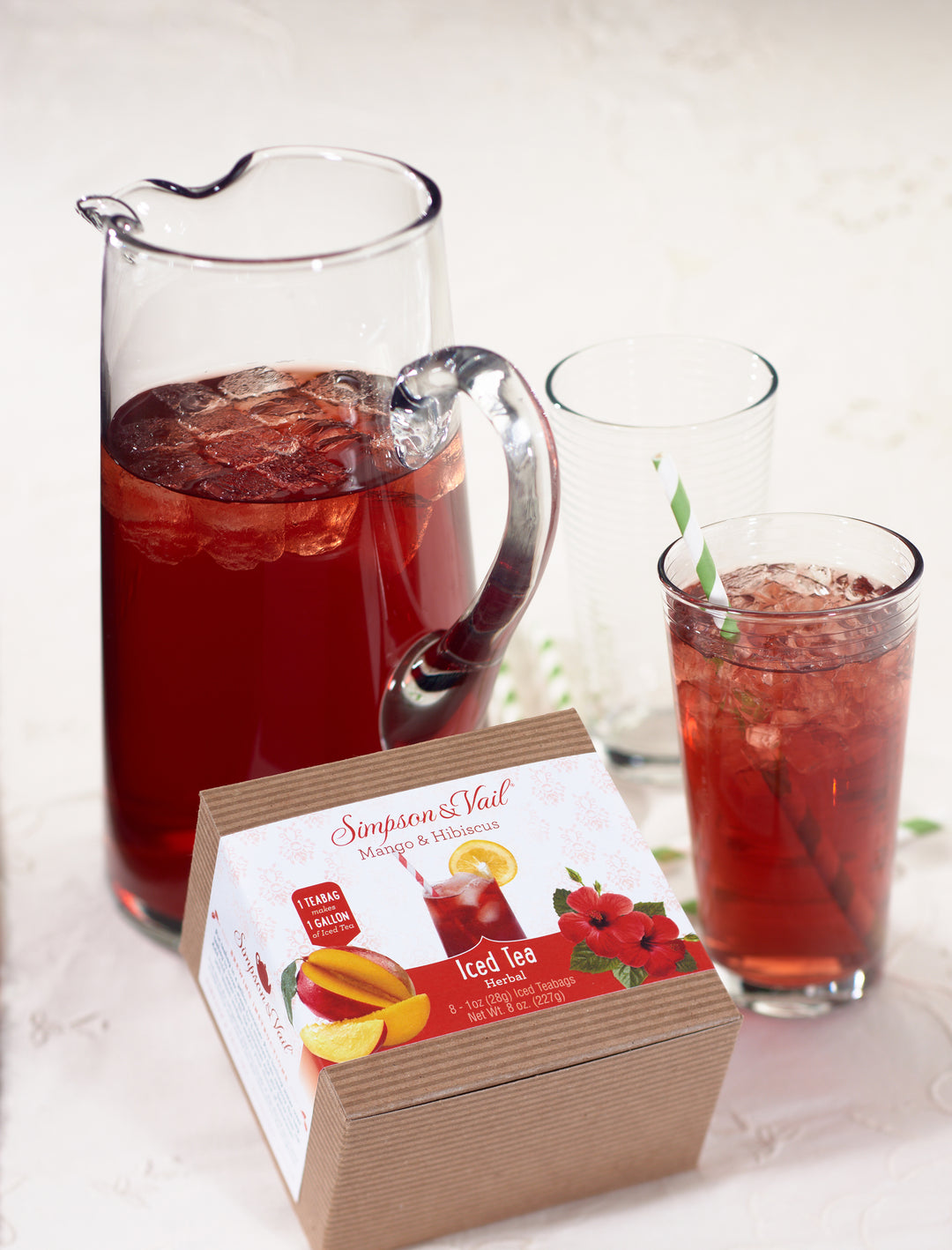 Mango & Hibiscus Herbal Fruits Iced Teabags Box with pitcher and glass of iced tea
