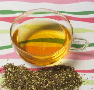 Organic Green Rooibos Herbal Tea Pile  and Brewed Cup